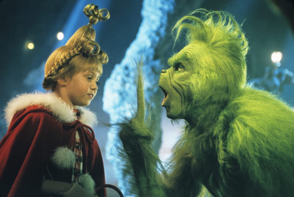 The Grinch shouts at a little girl. 