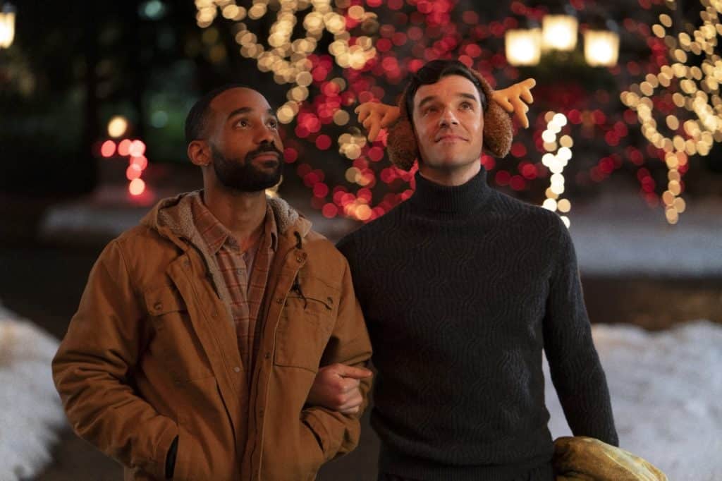 Two man stand. arm in arm, in a Netflix Christmas film.
