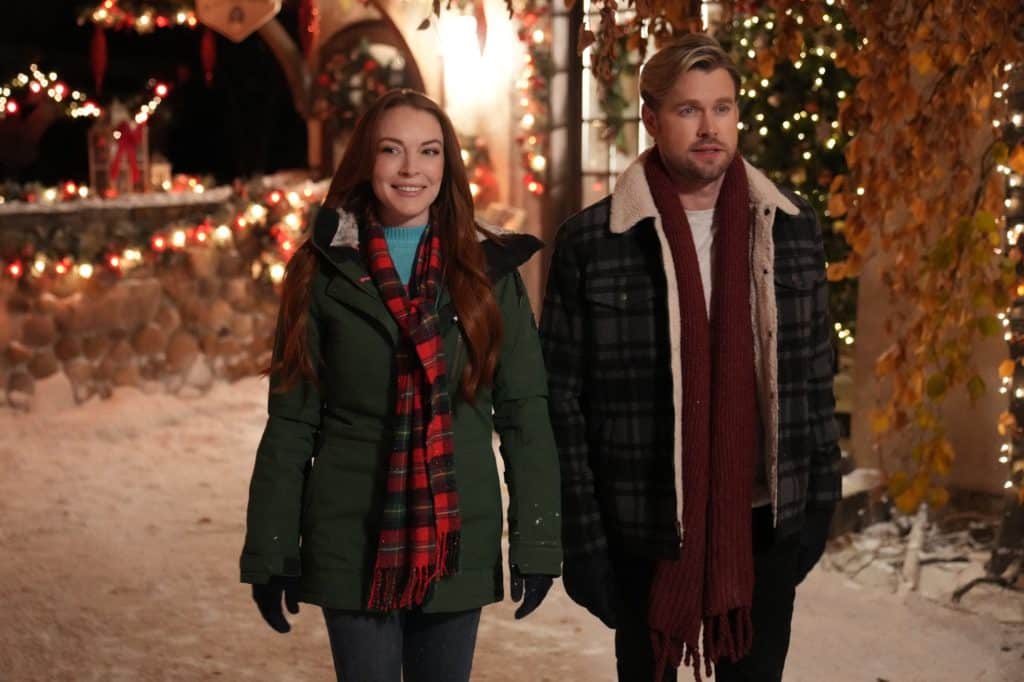 A man and a women walk side by side down a snowy street in a Netflix Christmas film.