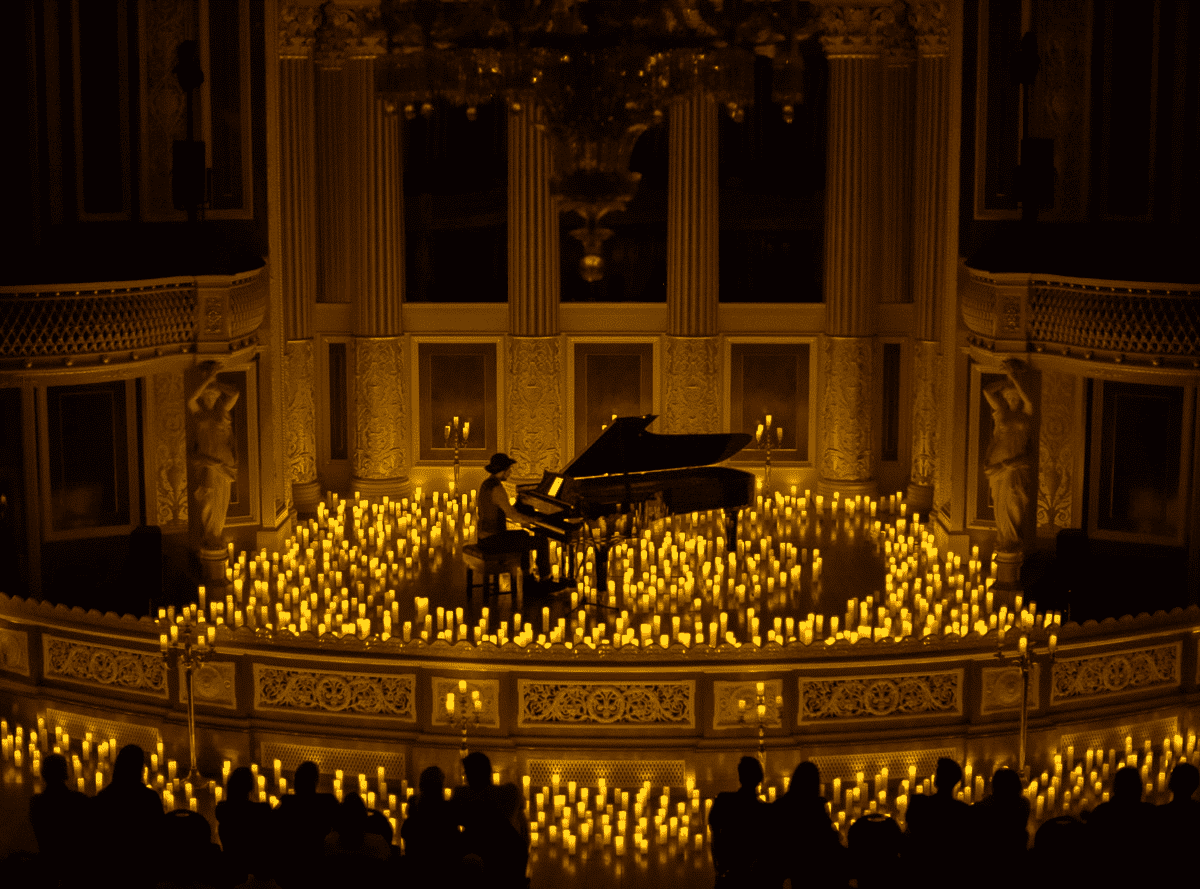 A pianist playing a piano on a stage covered by candles at St George's Hall in Liverpool.