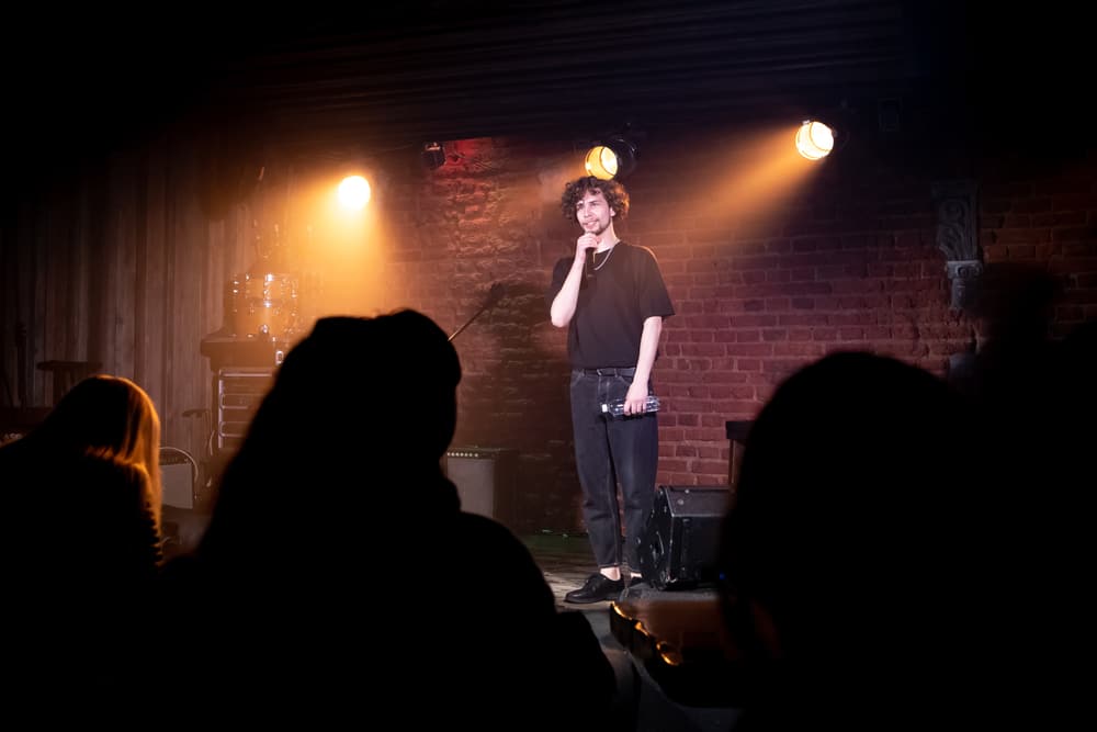 A standup comedian performs a set at a comedy club.