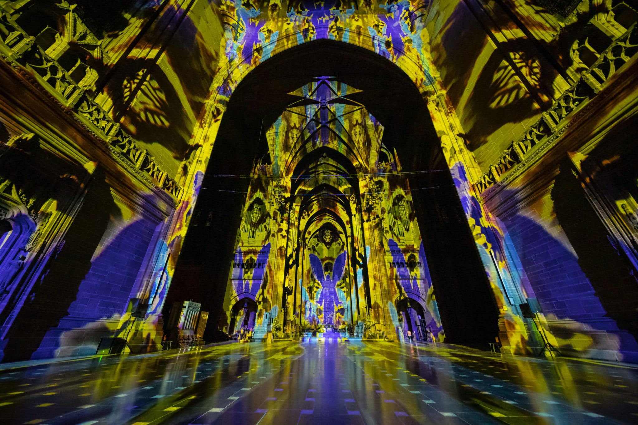 Liverpool cathedral illuminated with yellow and purple lights at 'The Light Before Christmas: The Angels Are Coming'