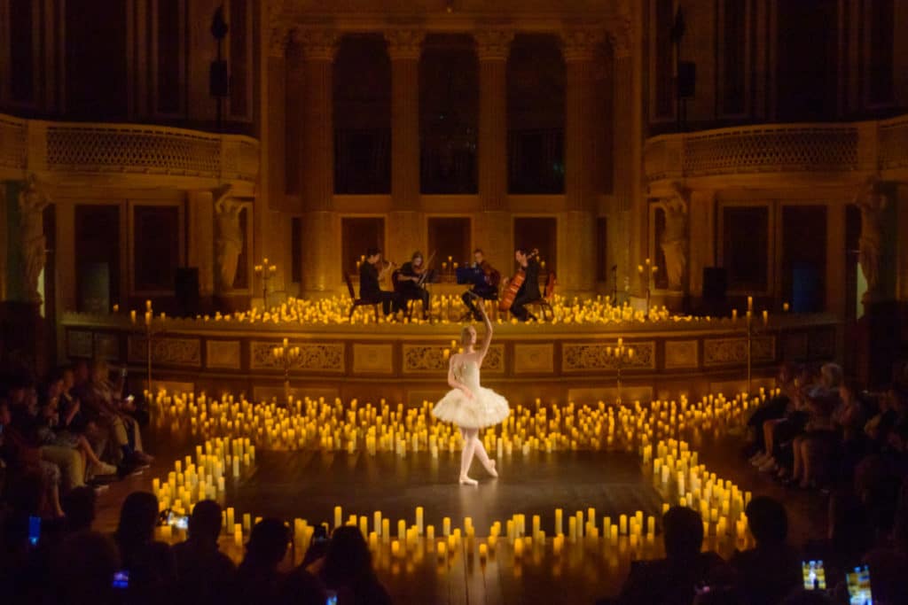 A ballerina dances, surrounded by hundreds of candles. 
