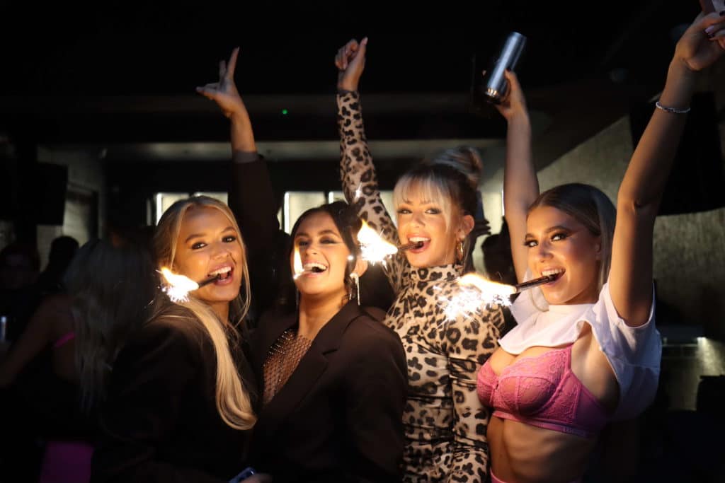 Four women stand with sparklers in their mouths at Noir Nightclub in Liverpool. 