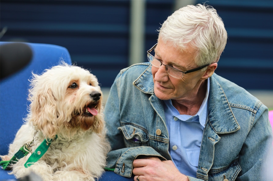 Paul O'Grady sits with a dog at Battersea Dogs and Cats Home.