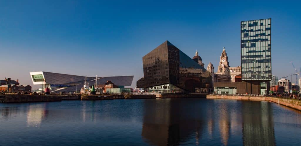 A picture of the Museum of Liverpool, Open Eye Gallery, and their surrounding buildings taken from across the water.