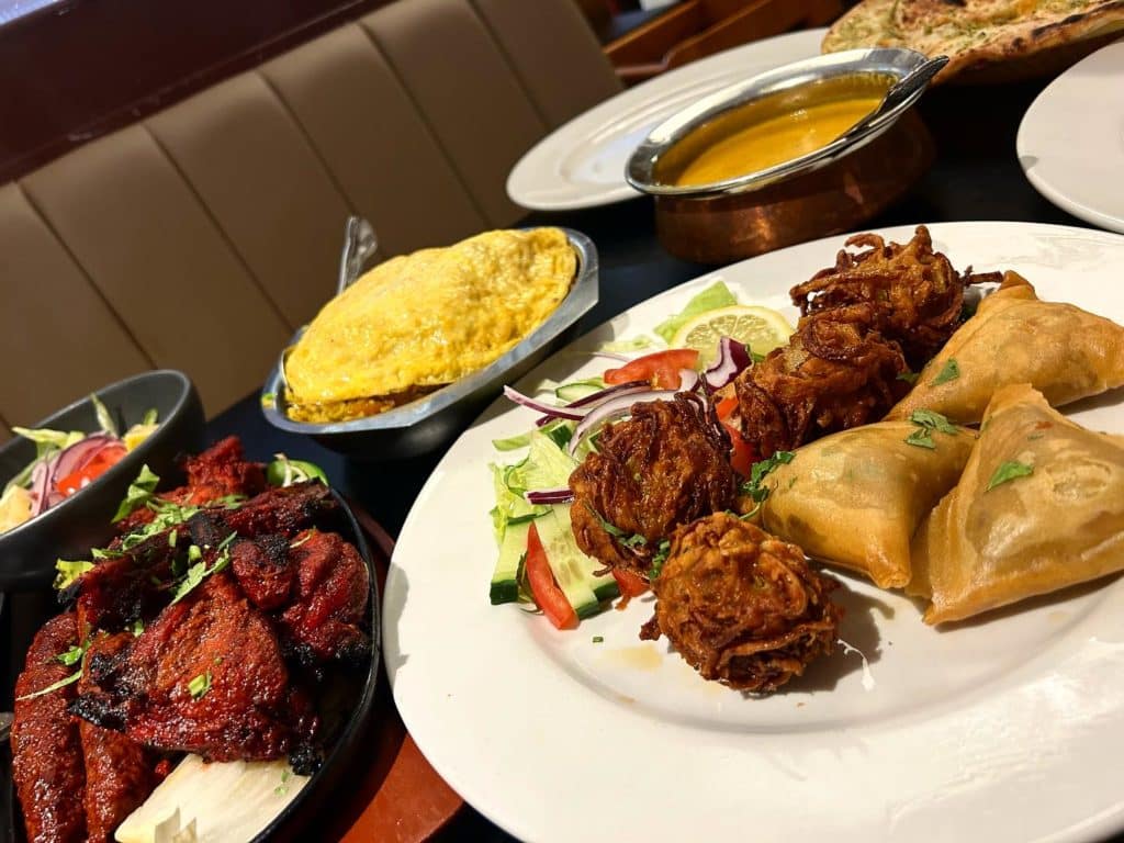 Indian dishes on a table including samosas and tandoori at Light Of Bengal.
